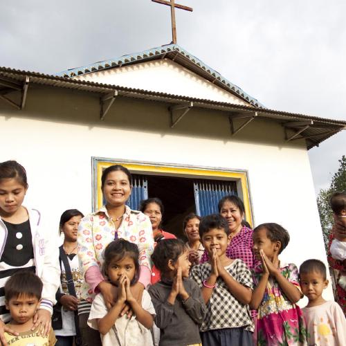 Cambodians smiling in front of a church