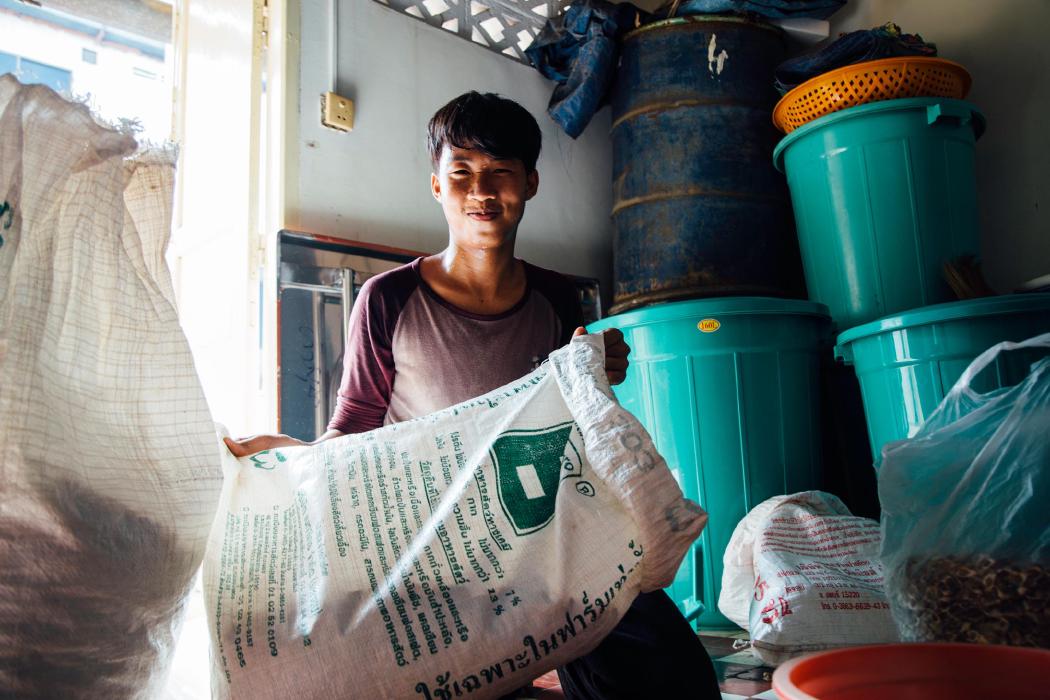 Man, smiling, and holding a bag of beans